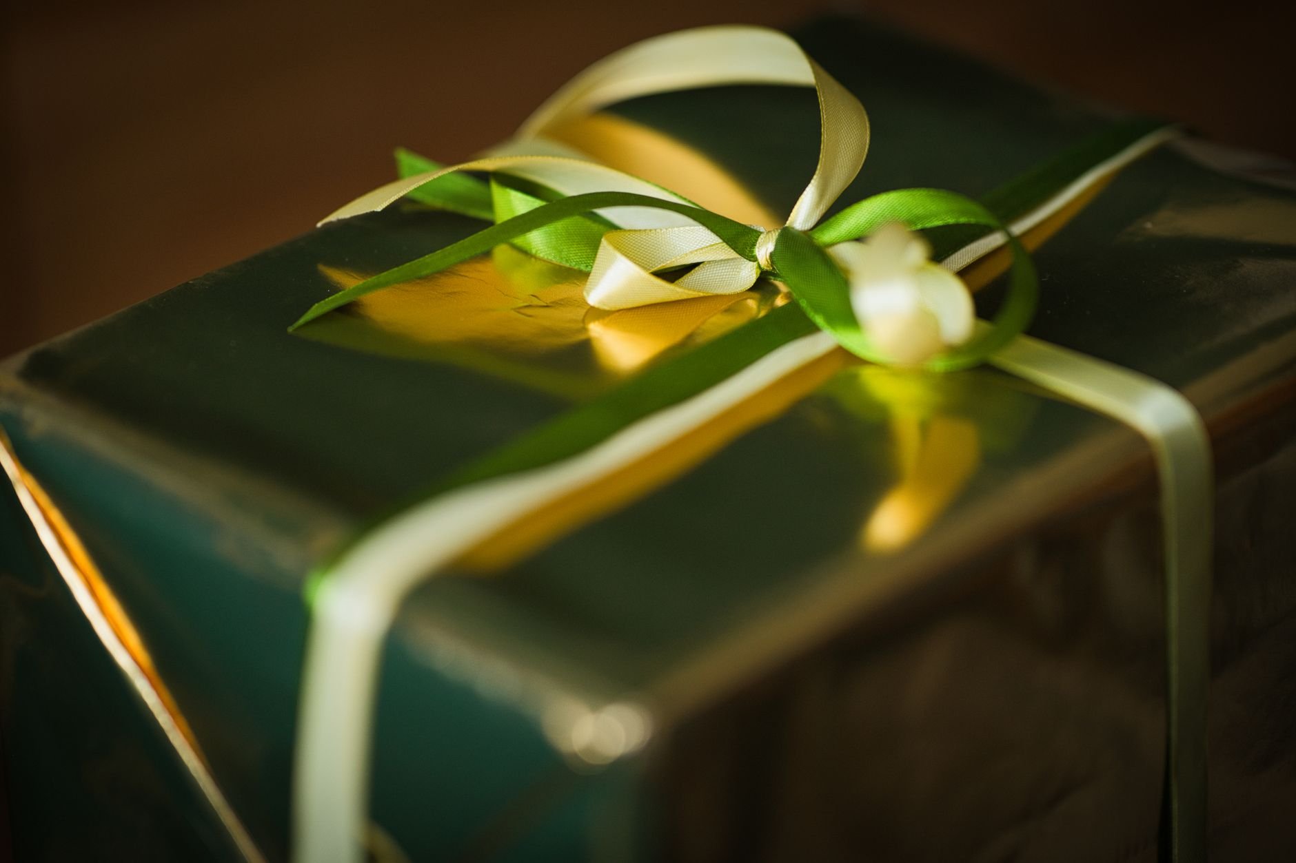 A beautifully wrapped gift box with gold ribbon, warmly lit